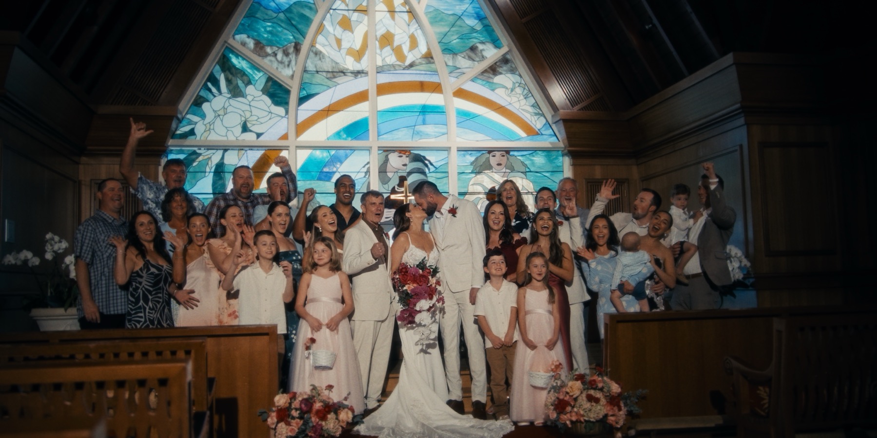 A newly married couple surrounded by their family and friends