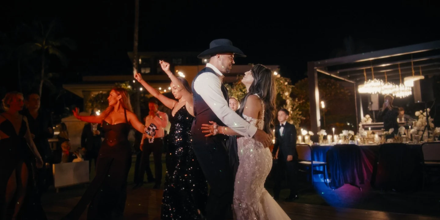 Michelle and Matthew kiss on the dance floor as guests celebrate around them.