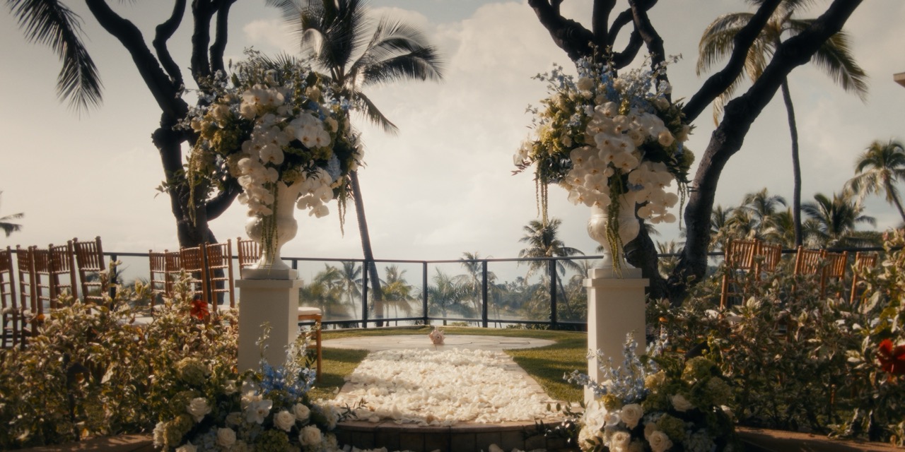 Empty Plumeria Point wedding ceremony setup framed by flowers, palms, and the Pacific Ocean