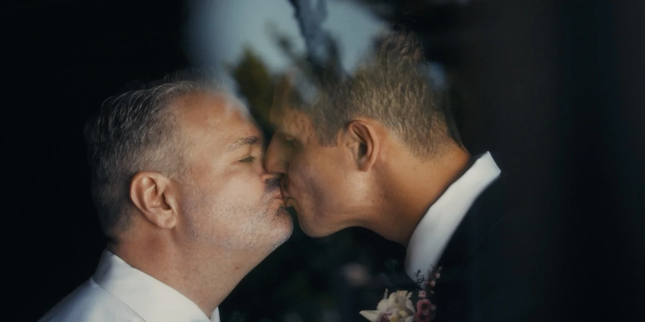 Jaime and Travis kiss in a close, quiet portrait.