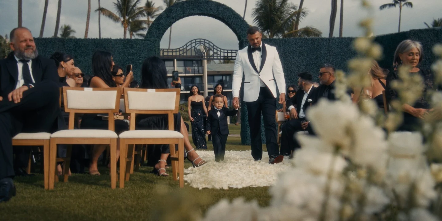 Matthew walks toward the ceremony holding a young child’s hand