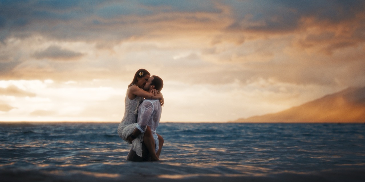 Fernanda and Felipe embracing in the ocean at sunset — South Shore, Maui.