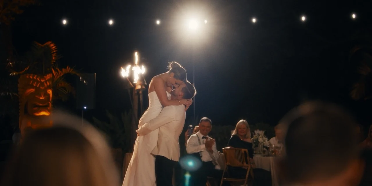 Caroline and Dylan kiss on the dance floor as fire rises behind them.