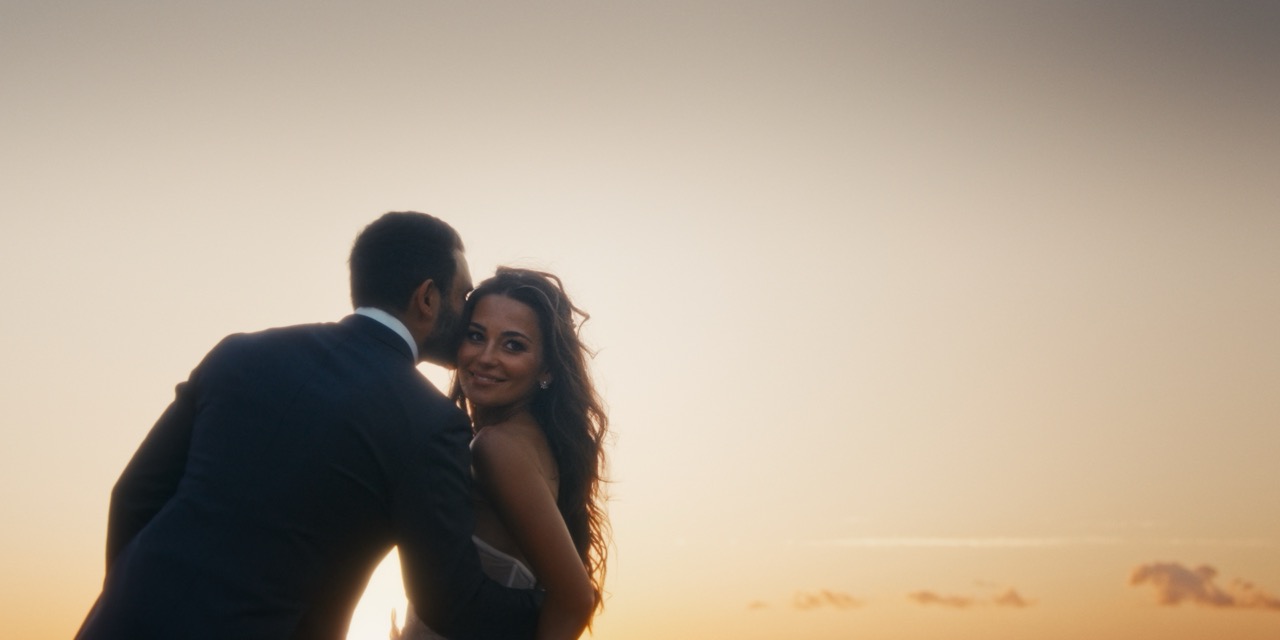 A newly married couple together at sunset