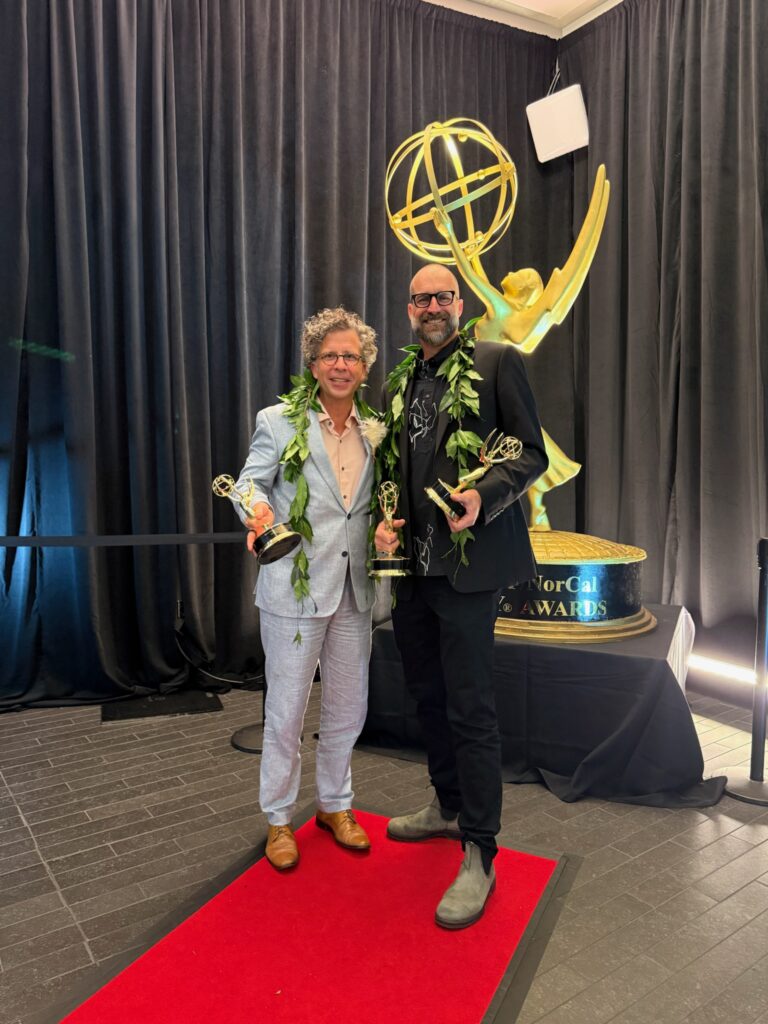Stephan Boeker and David Sellers pose with Pacific Storytellers’ Emmy statuettes at the 2026 ceremony.