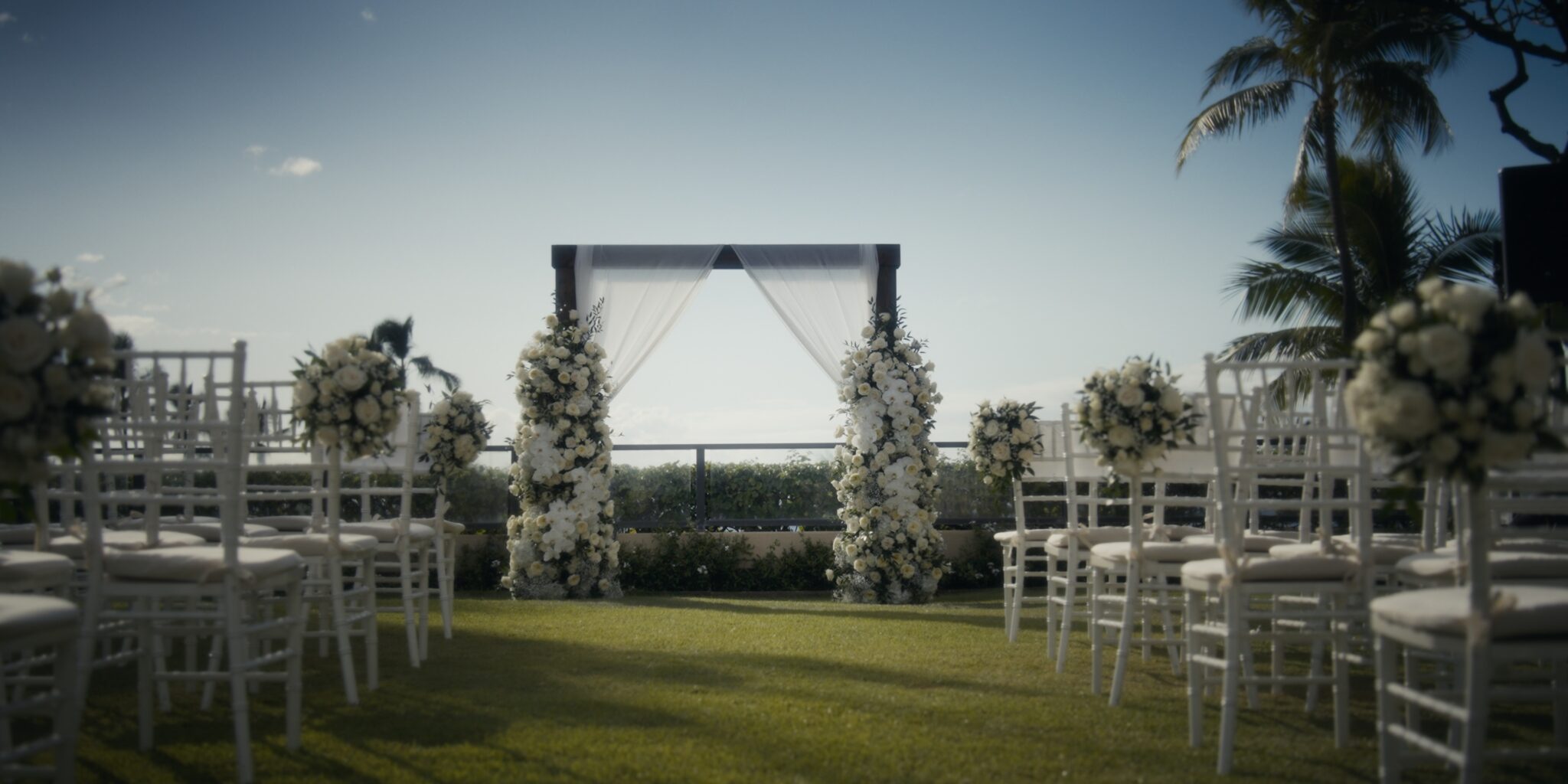 Empty Plumeria Garden wedding ceremony setup with white florals and ocean views at Four Seasons Maui
